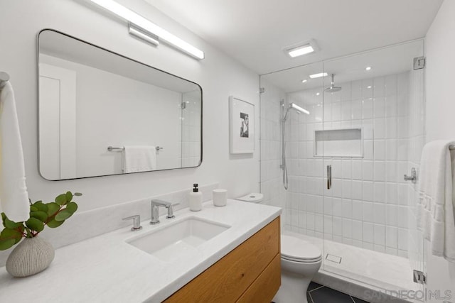 bathroom featuring vanity, toilet, and an enclosed shower