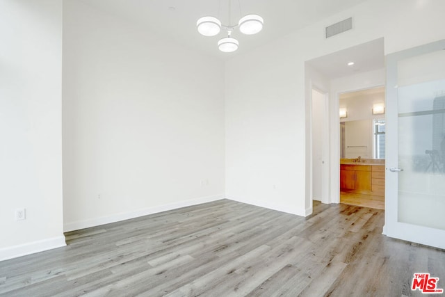 unfurnished room with sink and light hardwood / wood-style floors