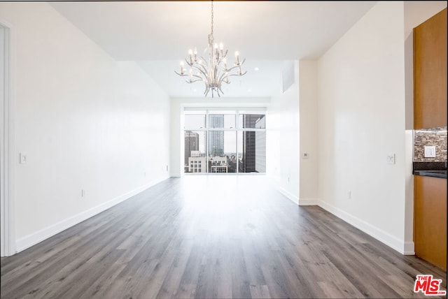 unfurnished dining area featuring an inviting chandelier and dark hardwood / wood-style floors