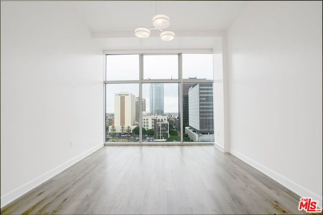 unfurnished room with hardwood / wood-style flooring and a notable chandelier