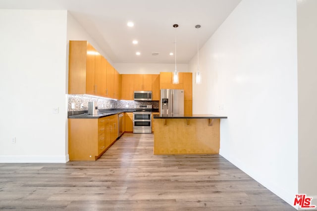 kitchen with stainless steel appliances, light hardwood / wood-style flooring, decorative backsplash, and decorative light fixtures