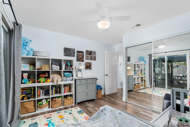 interior space with wood-type flooring, access to exterior, ceiling fan, and a closet