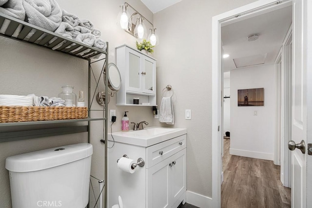 bathroom with hardwood / wood-style flooring, vanity, and toilet