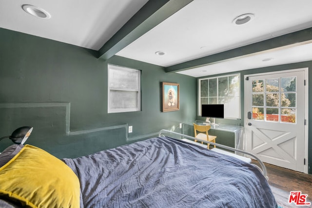 bedroom featuring hardwood / wood-style flooring and beam ceiling