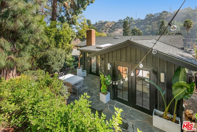 rear view of house featuring a mountain view and a patio area