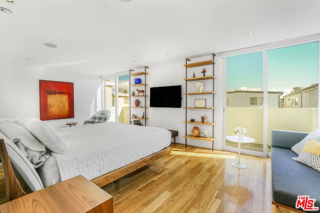 bedroom featuring light hardwood / wood-style flooring and floor to ceiling windows