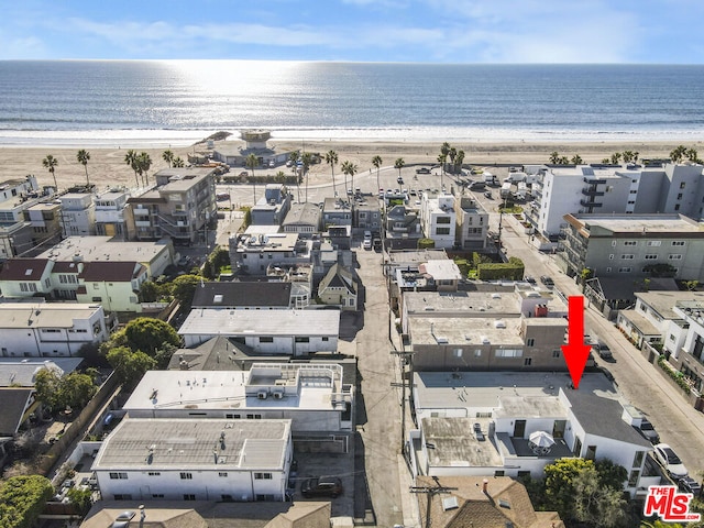 birds eye view of property featuring a water view and a beach view