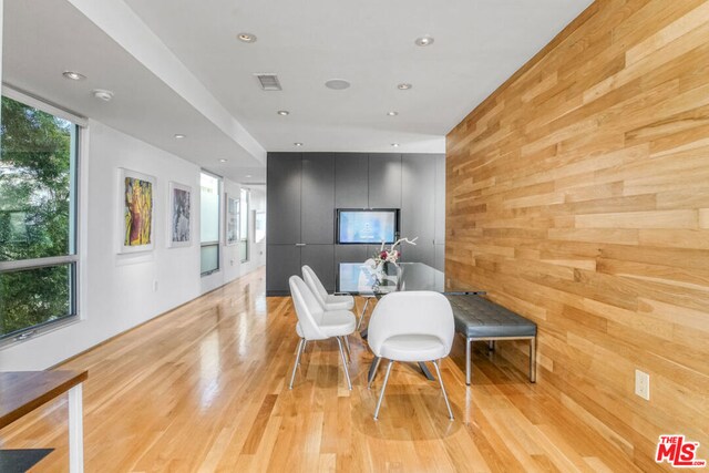 dining room featuring wooden walls and light wood-type flooring