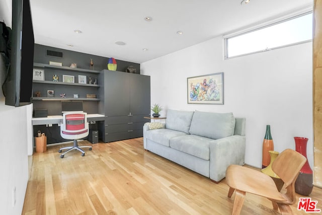 office featuring built in desk and light hardwood / wood-style flooring