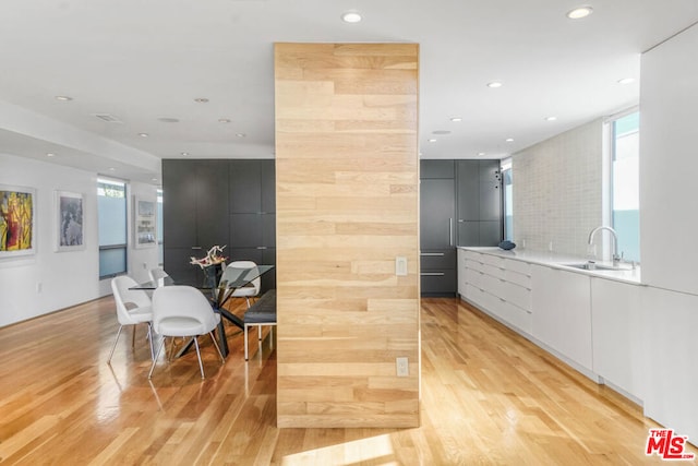 kitchen featuring white cabinetry, sink, plenty of natural light, and light wood-type flooring