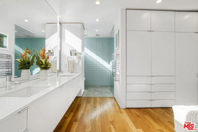 bathroom with vanity, hardwood / wood-style floors, and tile walls