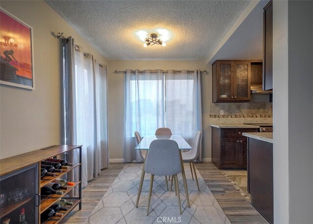 dining space featuring a textured ceiling and light wood-type flooring