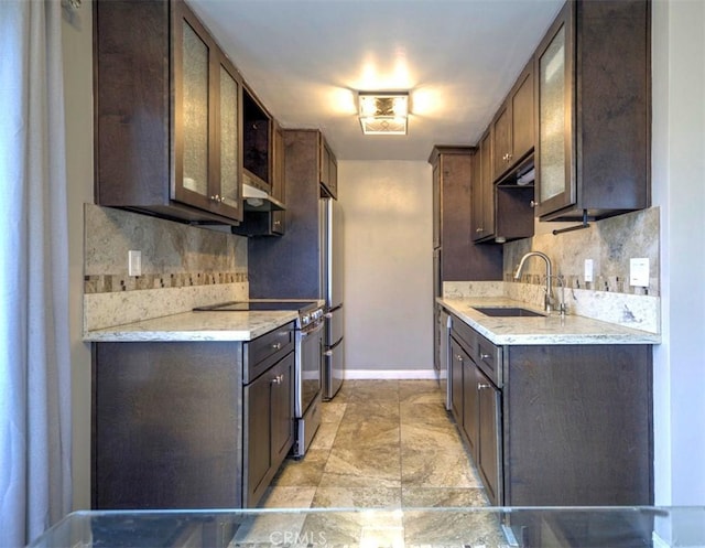 kitchen with dark brown cabinetry, sink, decorative backsplash, and appliances with stainless steel finishes