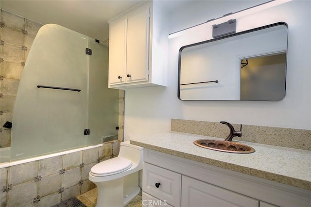 full bathroom featuring vanity, tiled shower / bath combo, and toilet