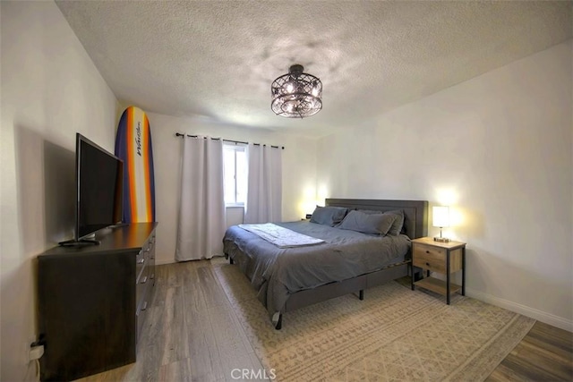 bedroom with hardwood / wood-style floors and a textured ceiling