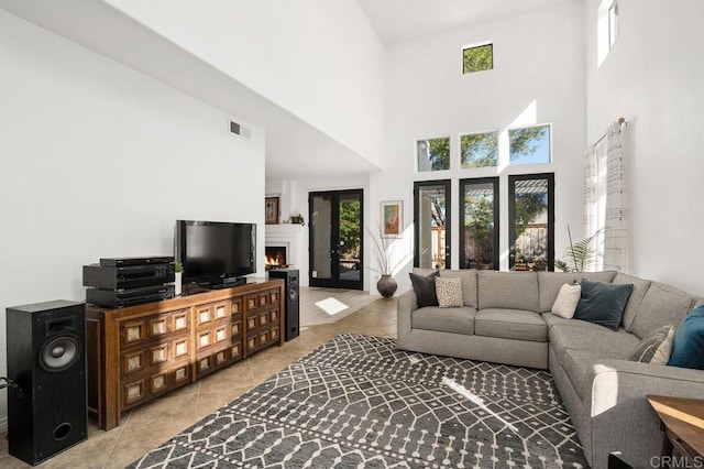 living room with a towering ceiling and light tile patterned floors