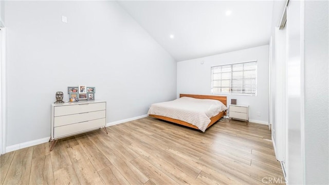 bedroom with vaulted ceiling and light wood-type flooring