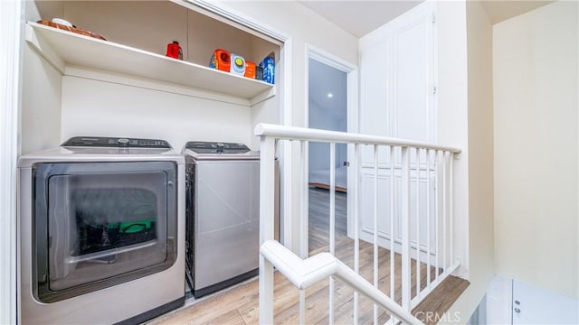 washroom with light hardwood / wood-style floors and washing machine and clothes dryer