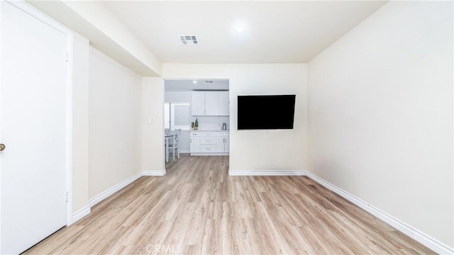 spare room with sink and light wood-type flooring