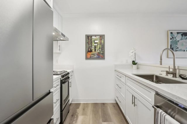 kitchen with sink, white cabinetry, stainless steel appliances, ornamental molding, and light hardwood / wood-style floors