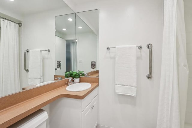 bathroom featuring walk in shower and vanity