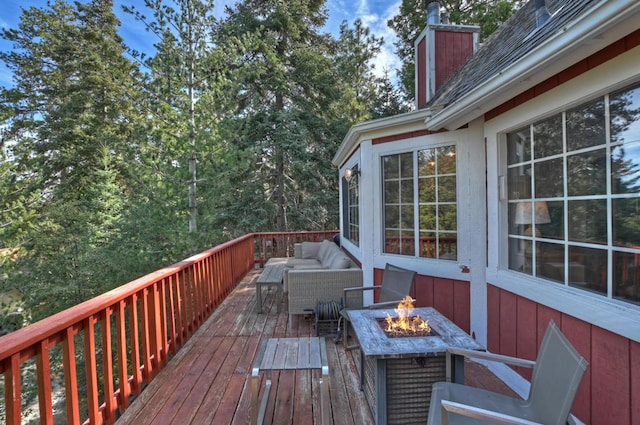 deck featuring an outdoor living space with a fire pit