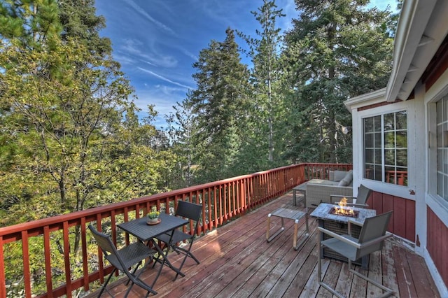 wooden terrace with an outdoor living space with a fire pit