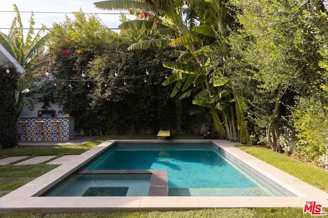 view of swimming pool with an in ground hot tub