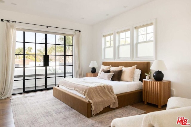 bedroom with hardwood / wood-style flooring and access to outside