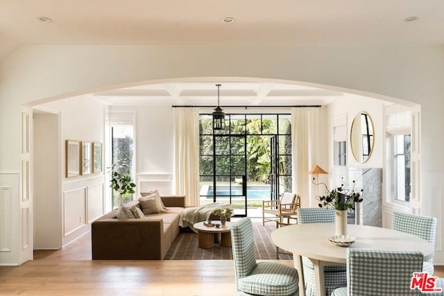 dining room featuring coffered ceiling, hardwood / wood-style flooring, and beamed ceiling