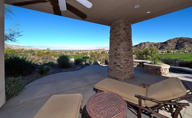 view of patio featuring a mountain view and ceiling fan