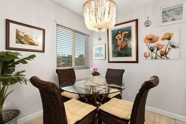 dining space featuring light wood-type flooring and a notable chandelier