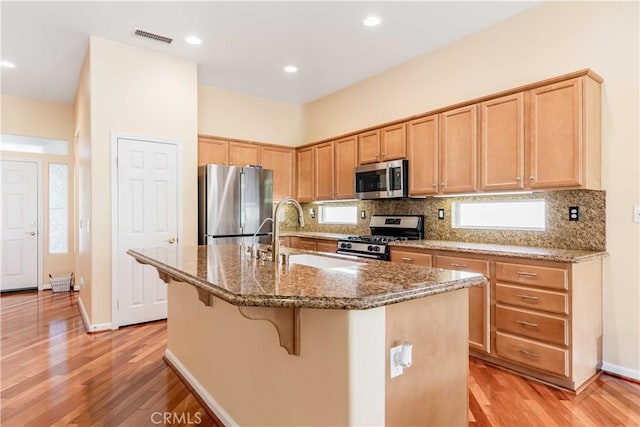 9431 Hughes Dr, Corona, CA 92883 - kitchen with stainless steel appliances, stone countertops, a sink, and tasteful backsplash