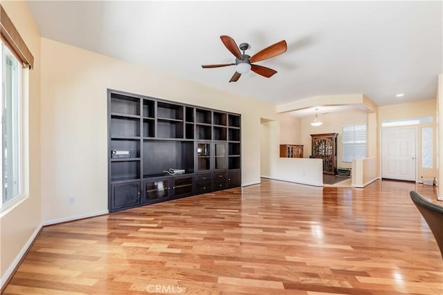 9431 Hughes Dr, Corona, CA 92883 - unfurnished living room with light wood finished floors, a ceiling fan, a wealth of natural light, and baseboards
