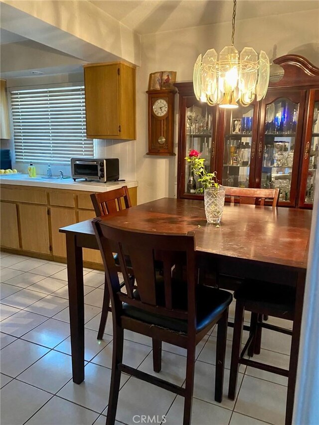 dining space featuring light tile patterned floors, sink, and a chandelier