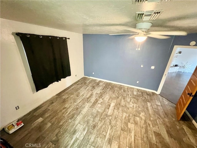 spare room featuring hardwood / wood-style flooring, ceiling fan, and a textured ceiling