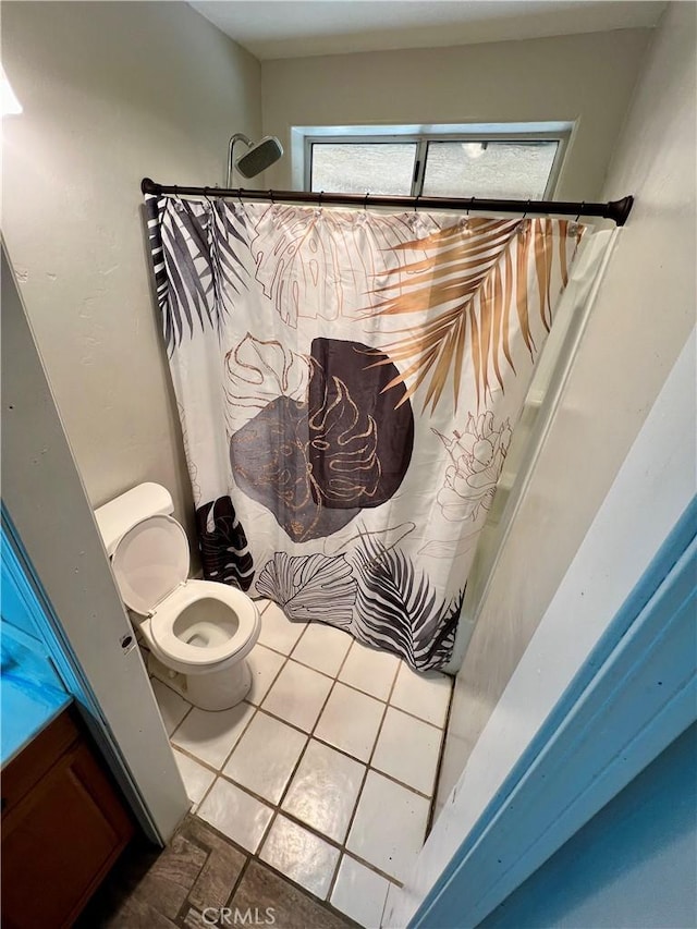 bathroom with toilet, curtained shower, and tile patterned flooring