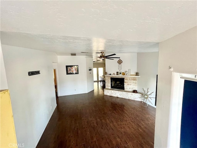 unfurnished living room featuring hardwood / wood-style flooring, ceiling fan, a fireplace, and a textured ceiling