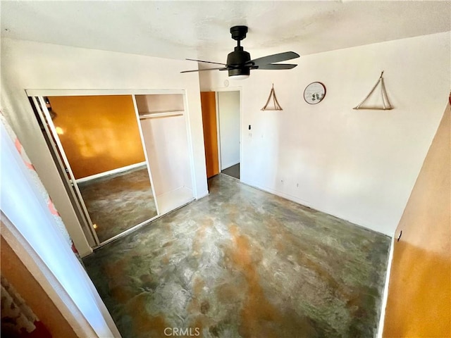 unfurnished bedroom with ceiling fan, a closet, and concrete floors