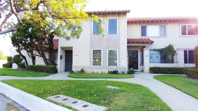 mediterranean / spanish home with a front yard