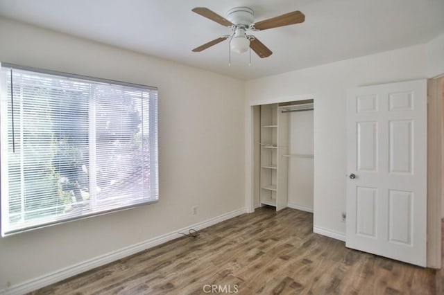 unfurnished bedroom featuring hardwood / wood-style flooring, ceiling fan, and a closet