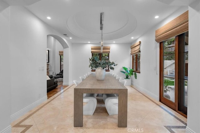 unfurnished dining area with a raised ceiling