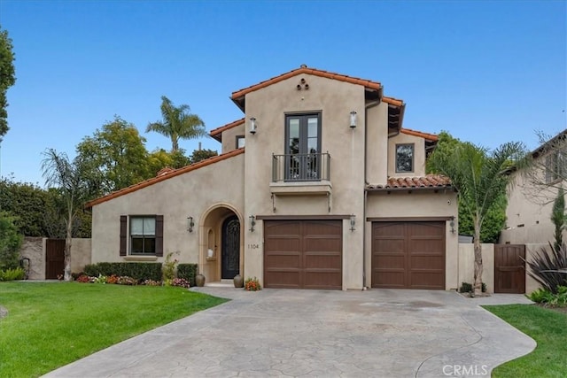 mediterranean / spanish-style house with a garage and a front lawn