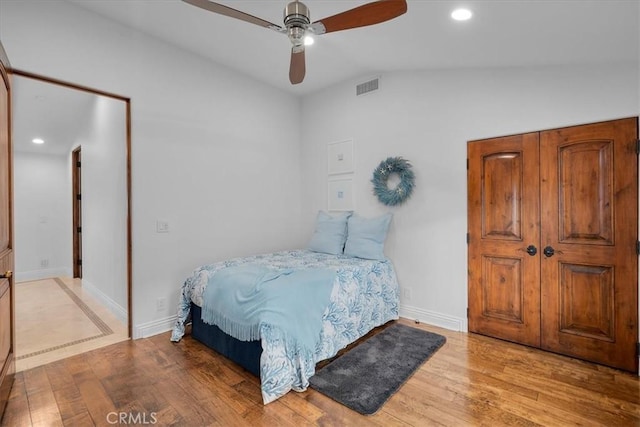 bedroom featuring lofted ceiling, light hardwood / wood-style flooring, and ceiling fan