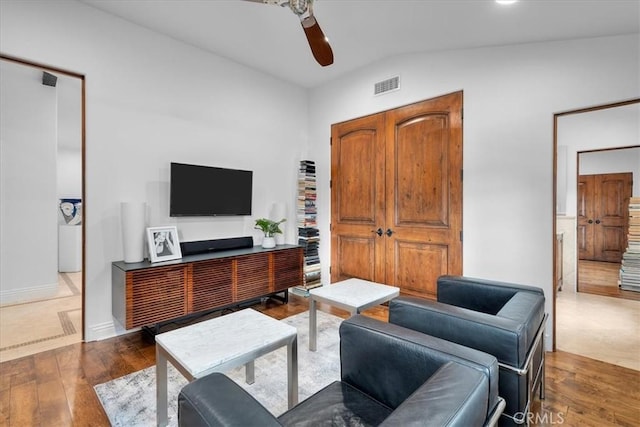 living room with dark hardwood / wood-style flooring, vaulted ceiling, and ceiling fan