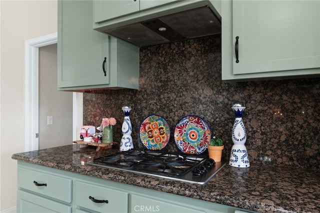 kitchen featuring green cabinetry, stainless steel gas cooktop, decorative backsplash, and exhaust hood