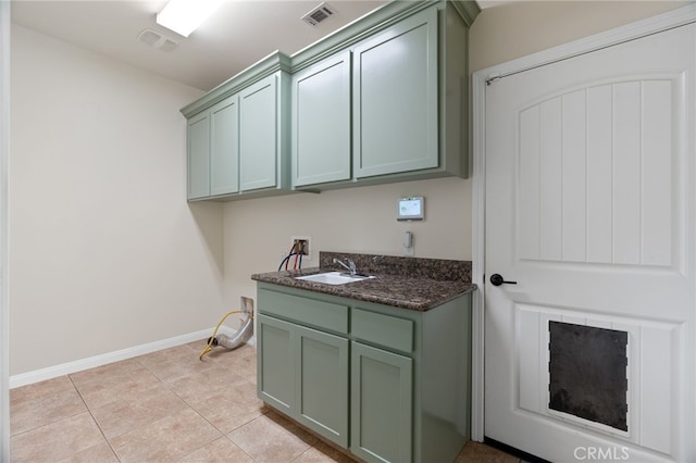 laundry area featuring cabinets, sink, washer hookup, and light tile patterned floors