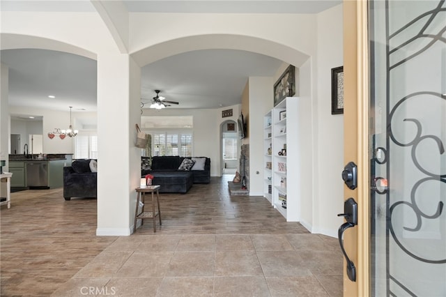 entryway with sink, ceiling fan with notable chandelier, and light hardwood / wood-style flooring