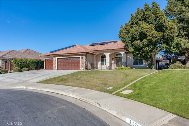 view of front of home featuring a garage, a porch, a front lawn, and solar panels