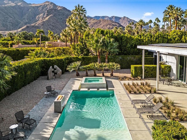 view of swimming pool featuring an in ground hot tub, ceiling fan, a mountain view, and a patio